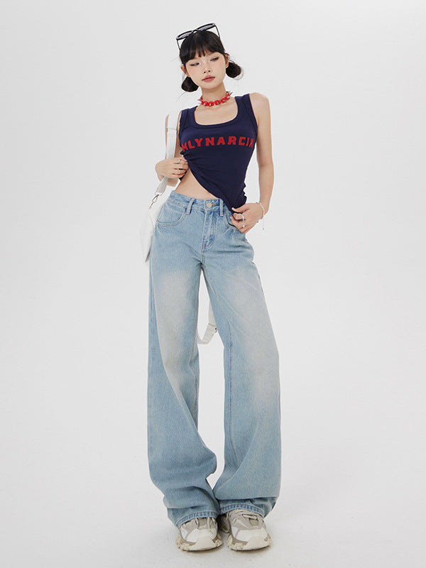 Standing model in navy crop tank, wide-leg light wash jeans, accessorized with sunglasses and white shoulder bag
