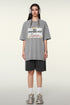 Woman wearing gray oversized t-shirt with "New Adventures Ahead" graphic print, dark shorts and silver headphones