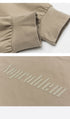 Beige sweatshirt cuff with ribbed elastic and embossed "Noproblem" text, highlighting soft fabric and raised lettering