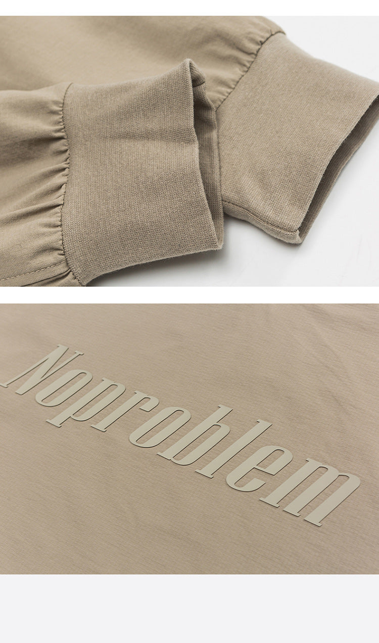Beige sweatshirt cuff with ribbed elastic and embossed "Noproblem" text, highlighting soft fabric and raised lettering