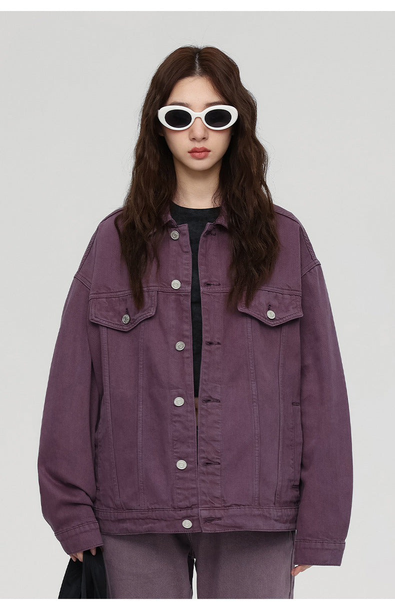 A woman wearing white oval sunglasses and purple oversized denim jacket against white background with relaxed styling