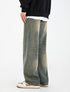A model wearing olive-green wide-leg jeans with unique seam detail, black sweatshirt layered over white tee, paired with retro gray and white sneakers