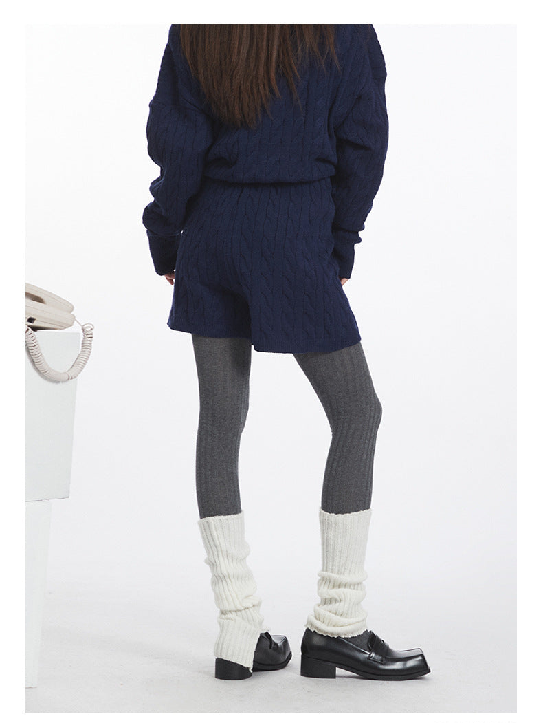 Back view of coordinated set emphasizing matching cable pattern on both sweater and shorts.