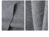 Extreme close-up of grey sweater's knit texture and fabric draping, showing detailed ribbed pattern.
