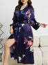 Navy blue floral satin robe with red and white flowers, side slit, worn in elegant setting