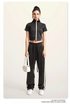 Dark gray mock neck crop top with front zip and white sleeve stripes, front view