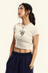 Model wears a white cropped T-shirt with a graphic print and navy sweatpants, styled with a silver chain necklace