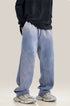 Model wearing light blue wide-leg sweatpants with black hoodie and gray athletic shoes against neutral background