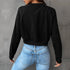 Back view of black cropped sweatshirt showing clean seam construction, paired with fitted light wash jeans