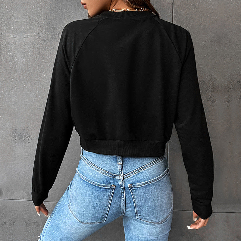 Back view of black cropped sweatshirt showing clean seam construction, paired with fitted light wash jeans
