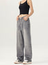 A woman modeling gray wide-leg jeans with a black crop top, standing against a plain white background
