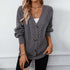 Oversized gray cardigan with cable knit pattern and wooden buttons, paired with white tank top and gold chain accessories