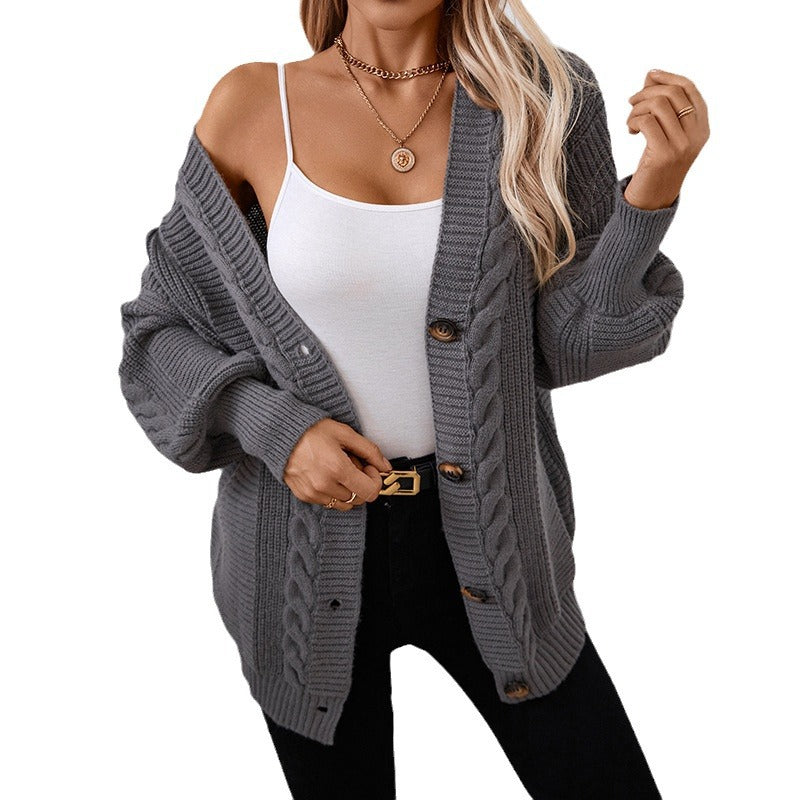 Gray cable knit cardigan with gold button closure and ribbed details, styled with white tank top and gold buckle belt