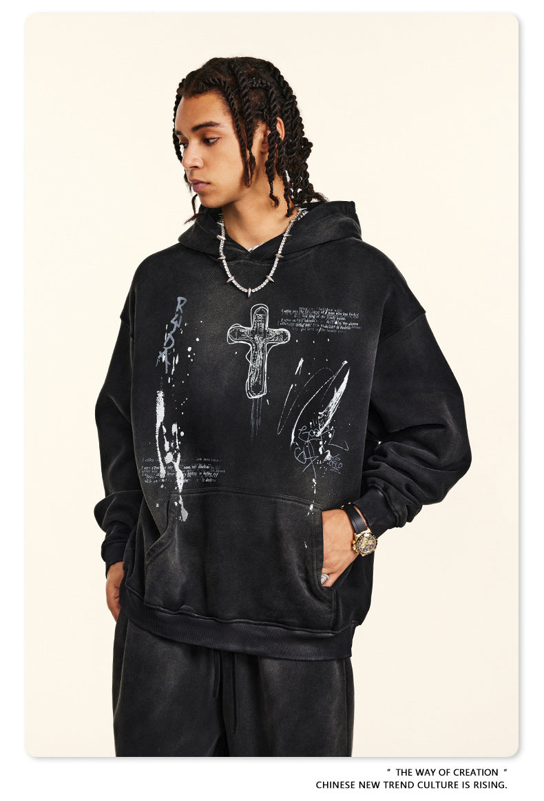 Black hoodie with distressed cross artwork and handwritten text details, shown with matching sweatpants