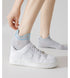 Demonstration of sock fit with white sneaker, highlighting antibacterial and breathable properties