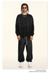GIF showing model rotating to display black splatter-print sweatsuit with silver chains and white sneakers