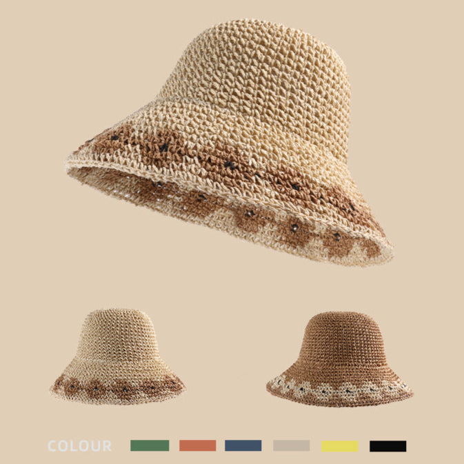 A beige woven bucket hat with a decorative brown floral pattern along the brim, displayed against a neutral background with smaller variations below.