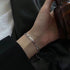 Silver Figaro chain bracelet on wrist, close-up view