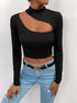 Black long-sleeve crop top with asymmetrical cutout, mock neck, paired with light blue jeans and gold chain belt