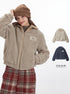 Model adjusting beanie while wearing beige sherpa jacket with Marule logo patch. Shown with color options and plaid pants