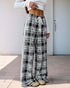 High-waisted black and white plaid wide-leg pants with a drawstring waist, paired with a white crop top and beige sneakers.