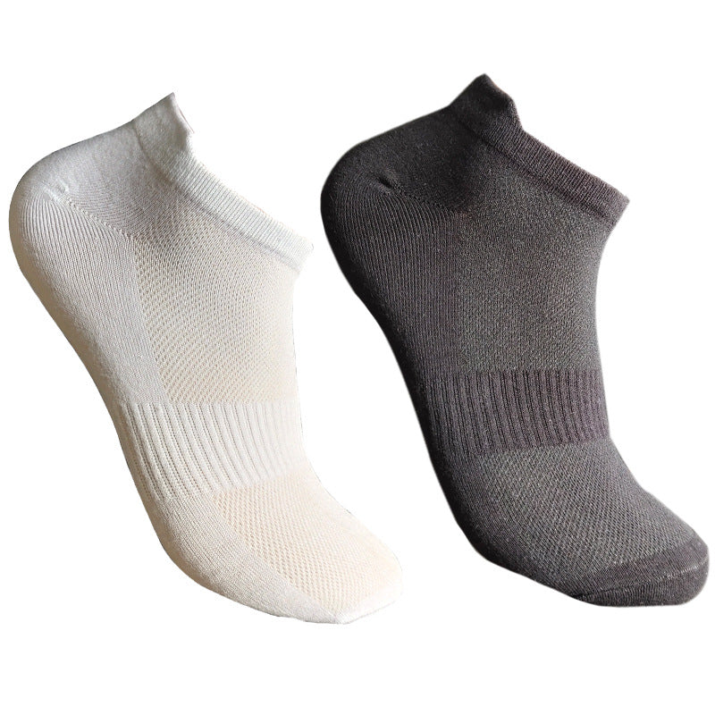 White and black low-cut ankle socks with mesh ventilation panels, cushioned soles and ribbed elastic cuffs against white background