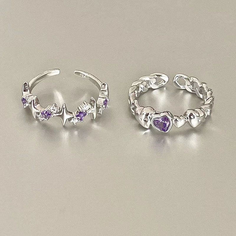 Two silver adjustable rings with purple accents on beige background - heartbeat design with crystal accents and heart-shaped gemstone chain ring