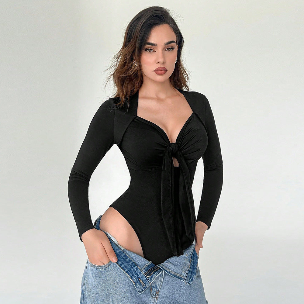 Woman wearing a black long-sleeve tie-front bodysuit with a plunging neckline, paired with light-wash jeans for a chic look.