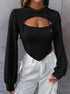 Woman wearing black textured crop hoodie with chest cutout detail paired with white cargo pants against gray wall