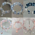 Collection of beaded bracelets featuring crystal beads with butterfly, fairy, and flower charms in blue and pink colors