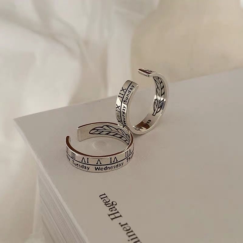Silver adjustable rings with Roman numerals and days of week engraving paired with leaf pattern design, displayed on white page