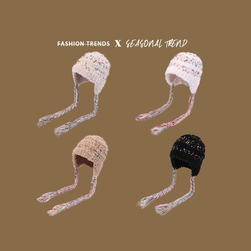 Fuzzy winter hats in white, beige, gray, and black with multicolored speckles and braided earflaps, showcasing seasonal fashion trends