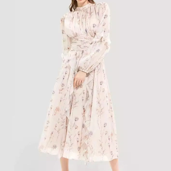 Woman wearing a vintage-inspired long-sleeve floral maxi dress with a high neckline, cinched waist, and delicate ruffle details, paired with silver heels