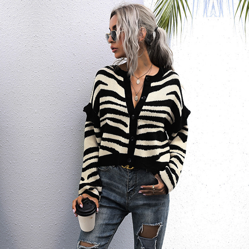 Zebra stripe cardigan, white top, ripped jeans, coffee cup, sunglasses