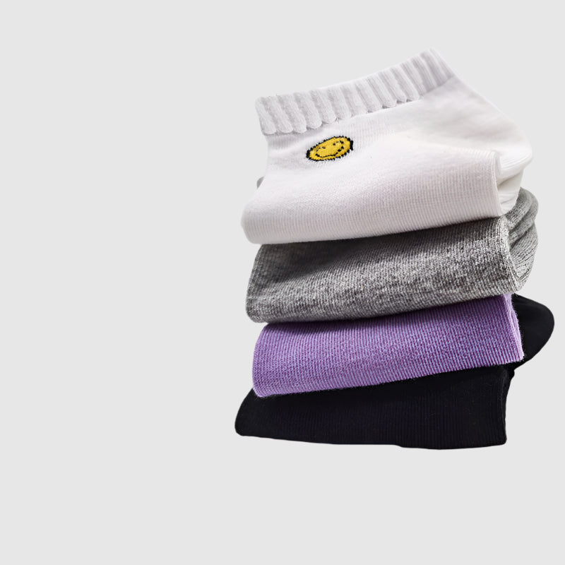 Stack of cotton ankle socks featuring smiley face embroidery in white, gray, purple, and black colors