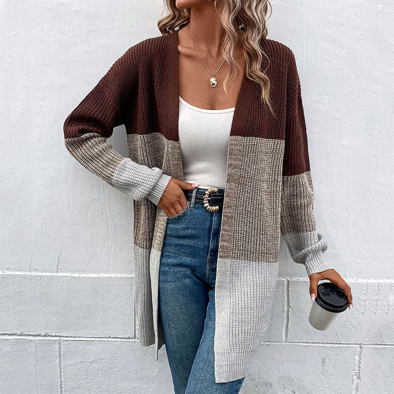 Color-block knit cardigan in brown and gray, worn over white top with blue jeans, featuring long sleeves and open front design