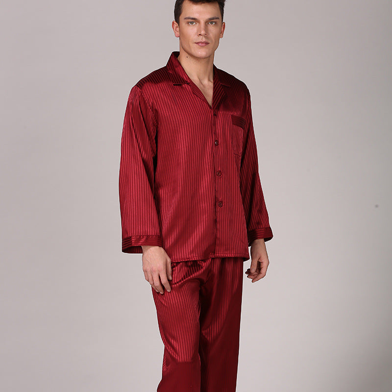 Model wearing burgundy striped silk pajama set with button-up long sleeve shirt and matching pants against neutral background