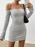 Woman wearing a gray ribbed off-shoulder mini dress with tie straps and long sleeves, holding a phone and black handbag