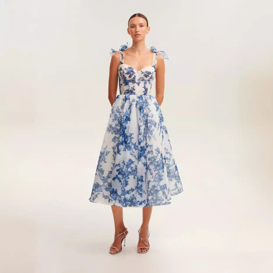 White and blue floral organza midi dress with bustier bodice and bow-tie straps, perfect for elegant summer events