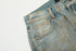 Close-up detail of light wash denim showing pocket construction and faded texture against white background