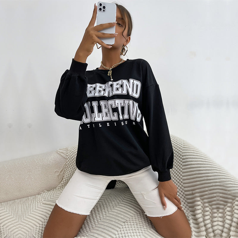 Mirror selfie showing black sweatshirt with "Weekend Collective" text paired with white denim shorts and gold necklace