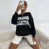 Mirror selfie showing black sweatshirt with "Weekend Collective" text paired with white denim shorts and gold necklace