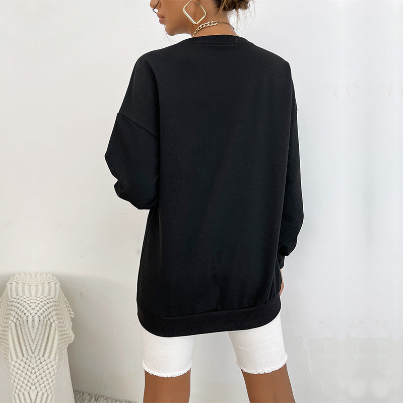 Back view of oversized black sweatshirt and white denim shorts with woman wearing geometric gold earrings