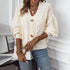 Cream cable knit cardigan with tortoiseshell buttons, model styling with gold jewelry and denim