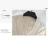 White cardigan detail showing delicate knit pattern and design stitching