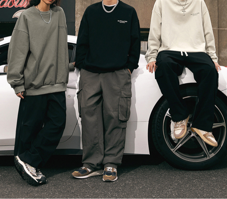 Group shot of streetwear outfits with oversized sweatshirts in olive, black, and white