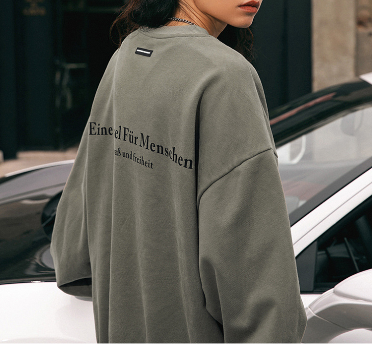 Gray sweatshirt with German text 'Eine Insel Für Menschen', casual streetwear style