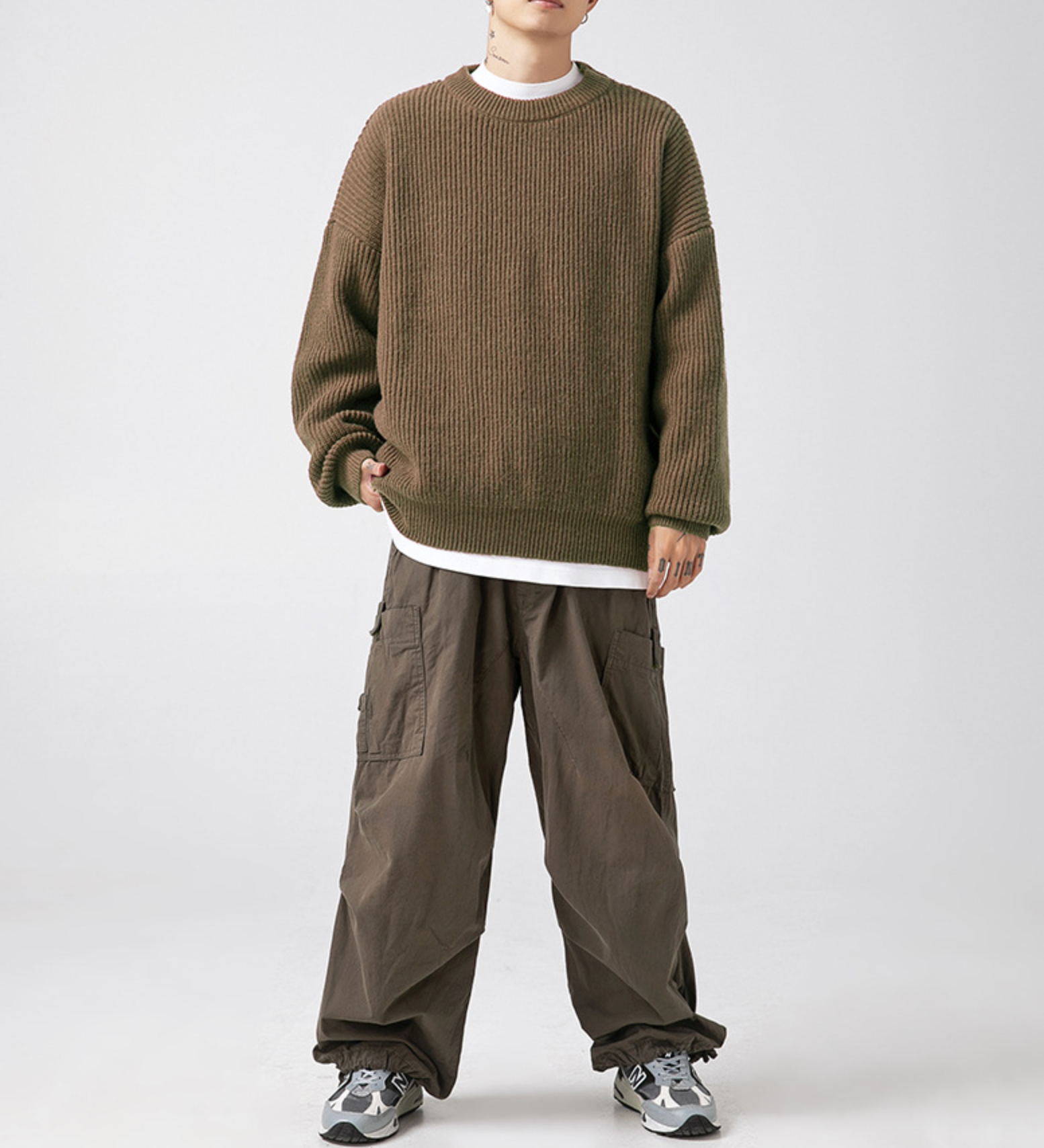 Olive brown oversized sweater layered over white tee with brown cargo pants and athletic shoes