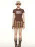 Model wearing brown mountain print tee, plaid mini skirt, baseball cap and tall boots, Y2K fashion style