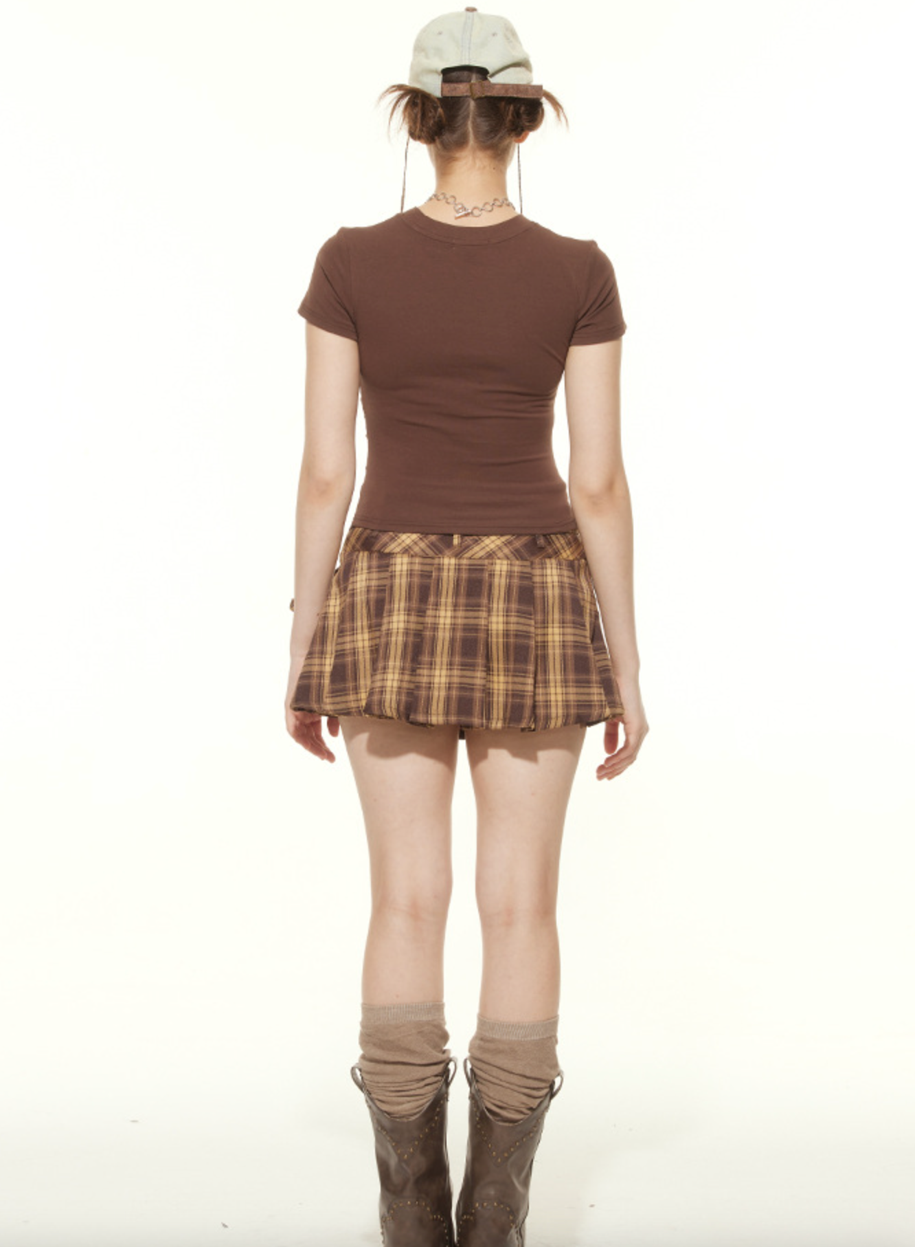 Back view of brown tee and plaid mini skirt outfit with leg warmers and boots, vintage aesthetic